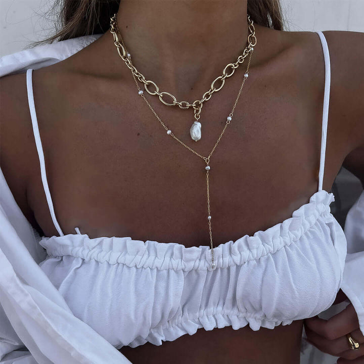 Model wearing a stylish Lotus Chain Necklace featuring a freshwater pearl layered over a white top.