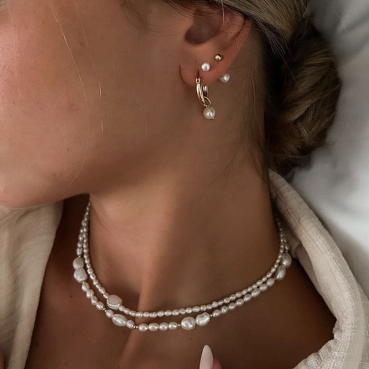 Close-up of a woman wearing the Monaco Necklace with layered pearls and gold beads, showcasing an elegant style.