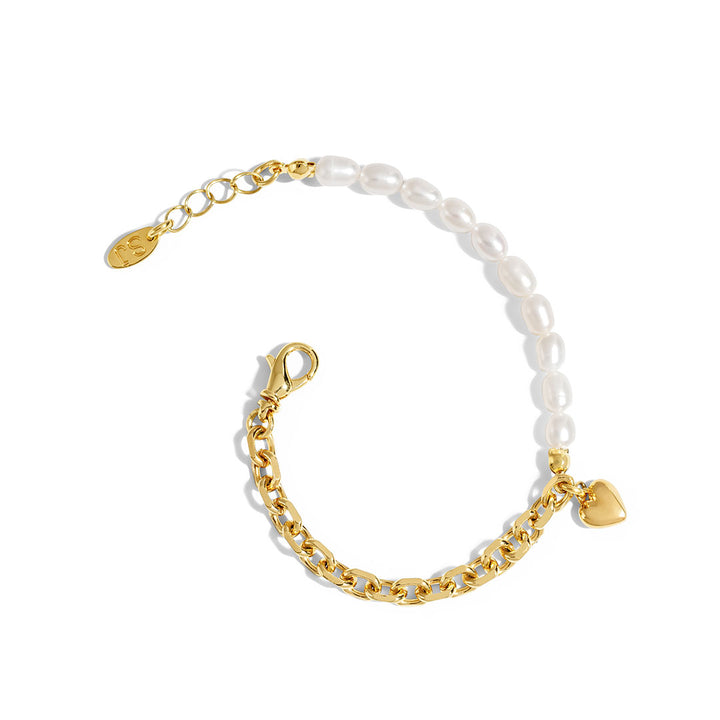 Nina Bracelet featuring a delicate chain, natural pearls, and a bold heart charm, perfect for stylish layering.