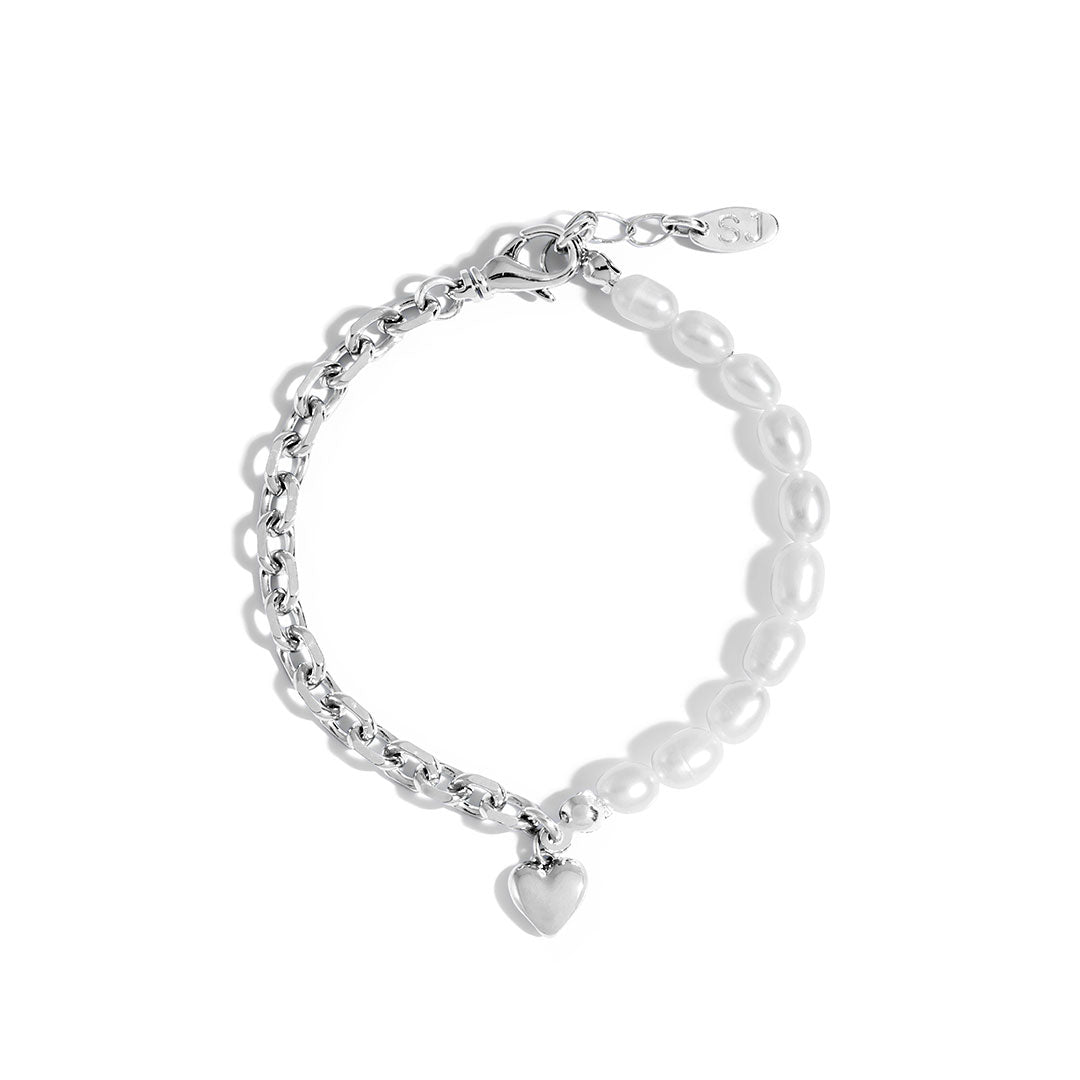 Nina Bracelet featuring a delicate chain with natural pearls and a bold heart charm, perfect for layering.