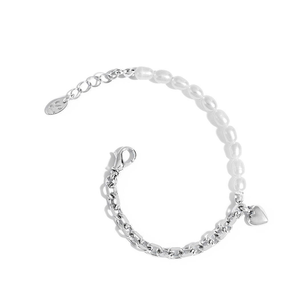 Nina Bracelet featuring a delicate chain, natural pearls, and a bold heart charm.