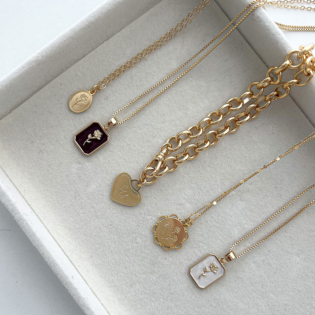 Beautiful assortment of gold necklaces including the Lace Necklace with rose pendants.