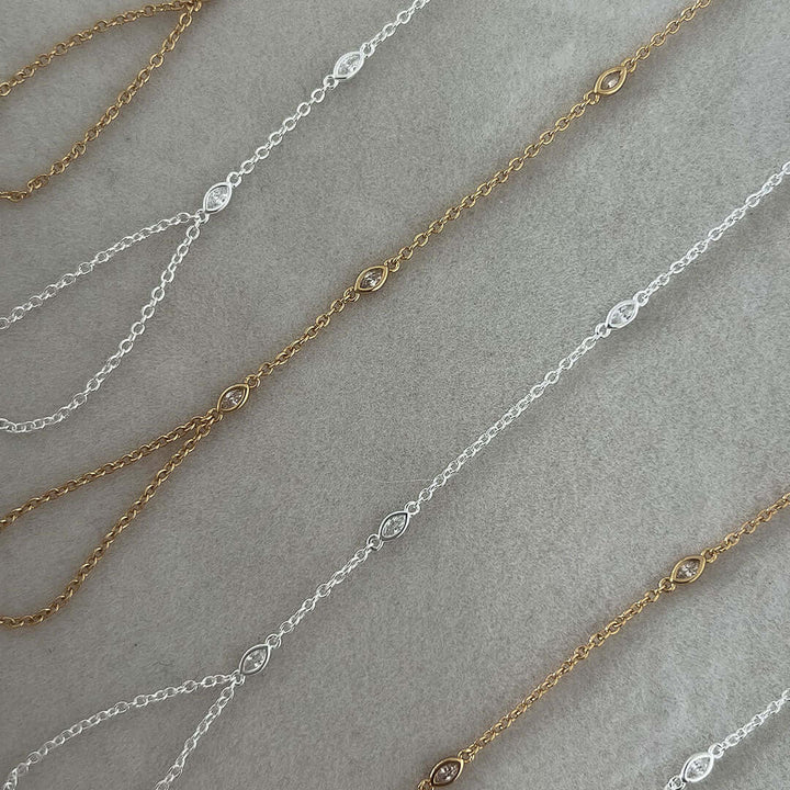 Sol Hand Chain Bracelet showcasing intricate gold and silver chains with sparkling details on a smooth surface.