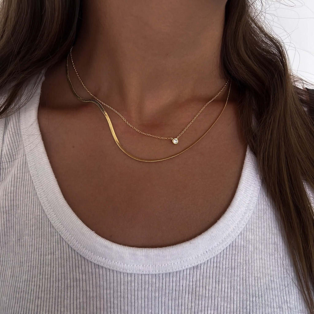 Tiny Jessica Necklace layered with delicate gold chain and a small charm, perfect for stylish outfits.