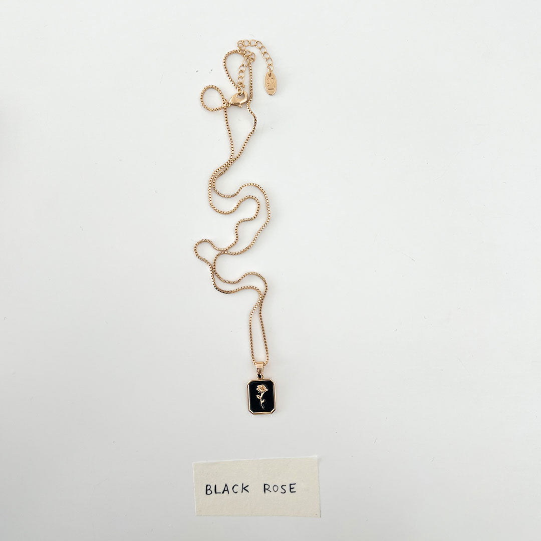 Black Rose Necklace featuring a striking black pendant with a delicate rose design on a gold chain.