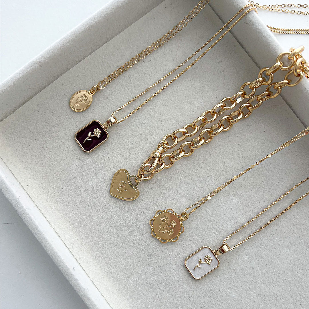 Eva Necklace and other layered gold chain necklaces featuring rose details in a jewelry box.