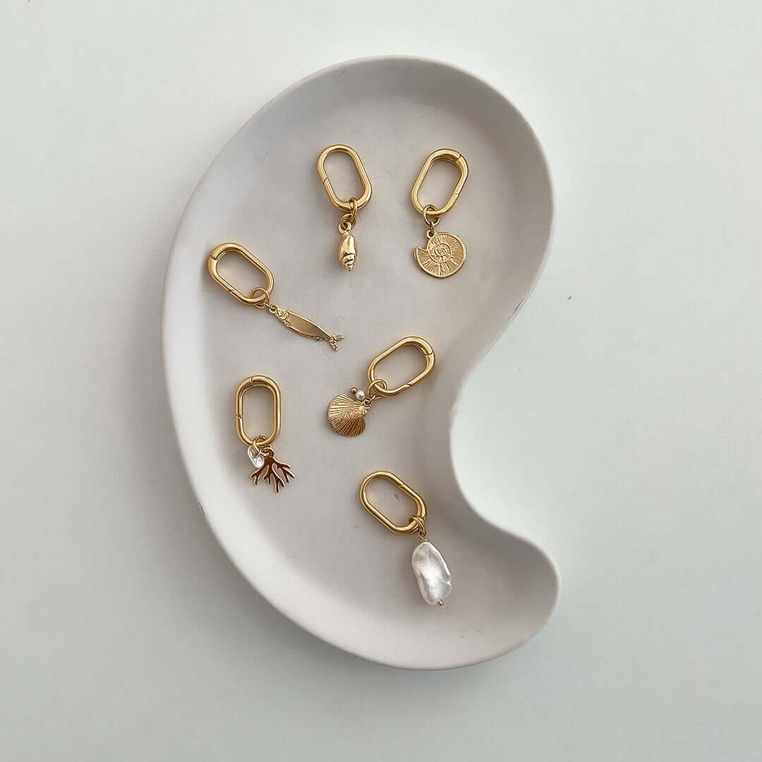 Stylish Coral Charm accessories displayed on a decorative dish, perfect for personalizing bags or keys.