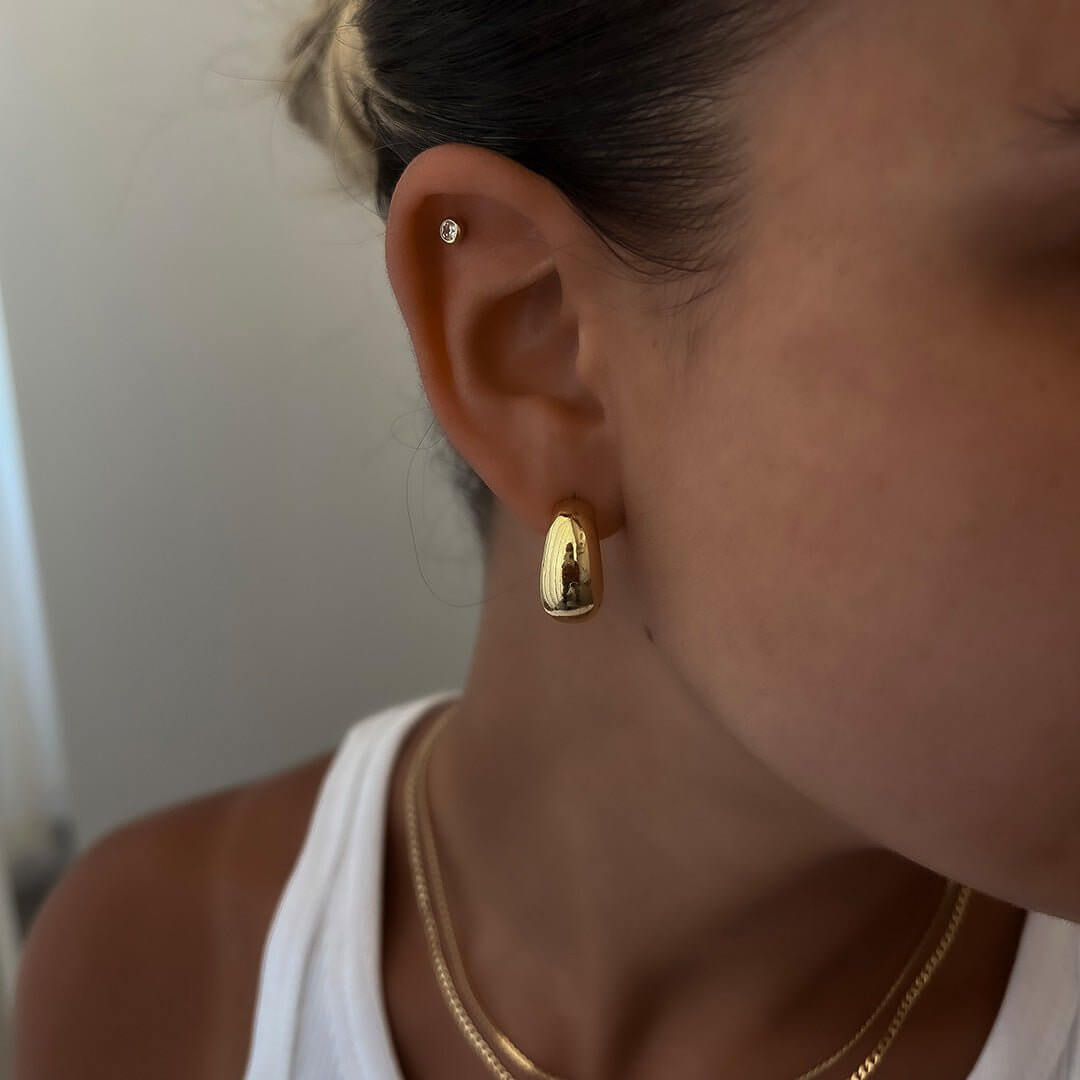 Chris Earrings - elegant gold stud earrings showcasing a delicate shine, perfect for adding glam to everyday outfits.