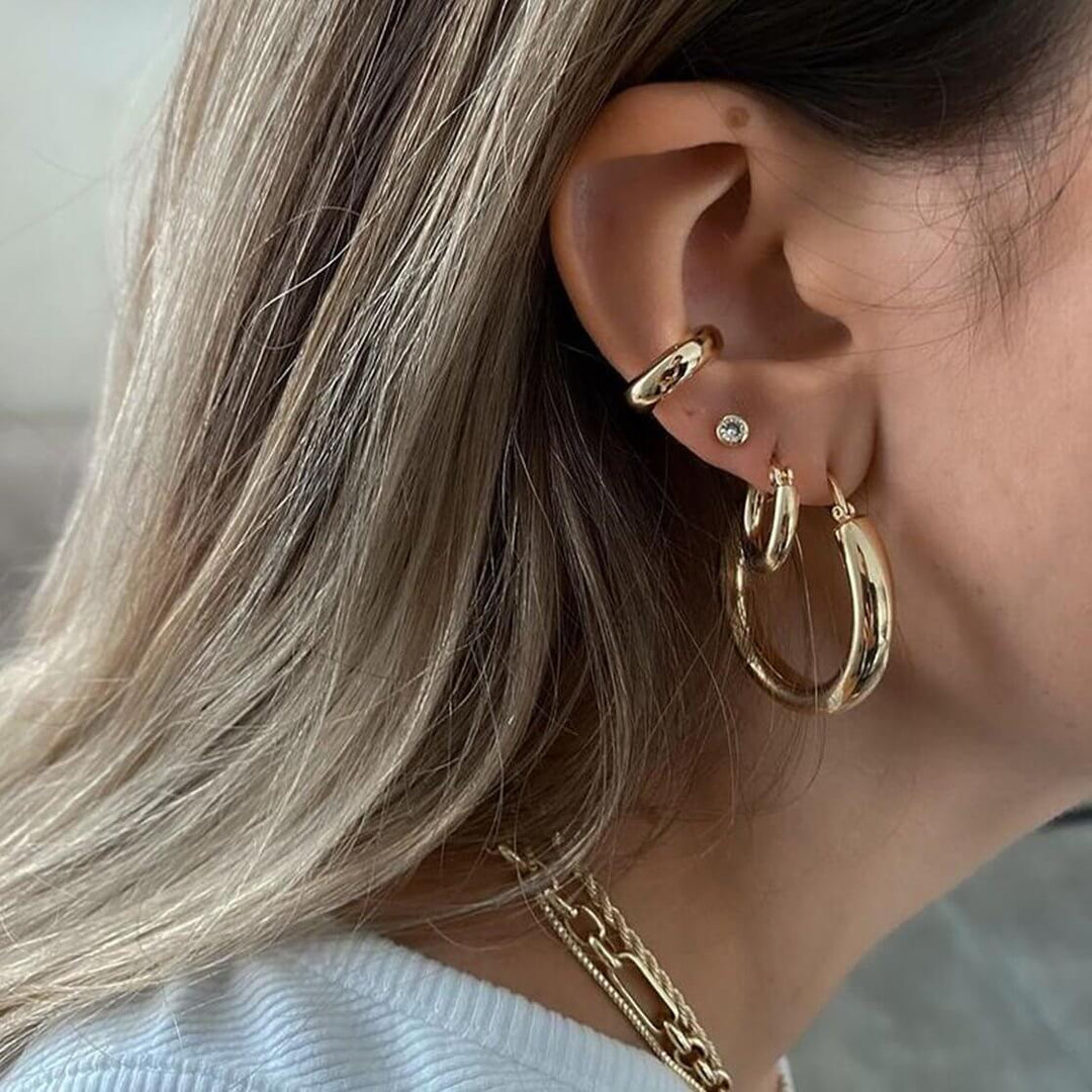 Close-up of a model wearing Chris Earrings, showcasing round crystal studs and gold hoops for elegant everyday style.