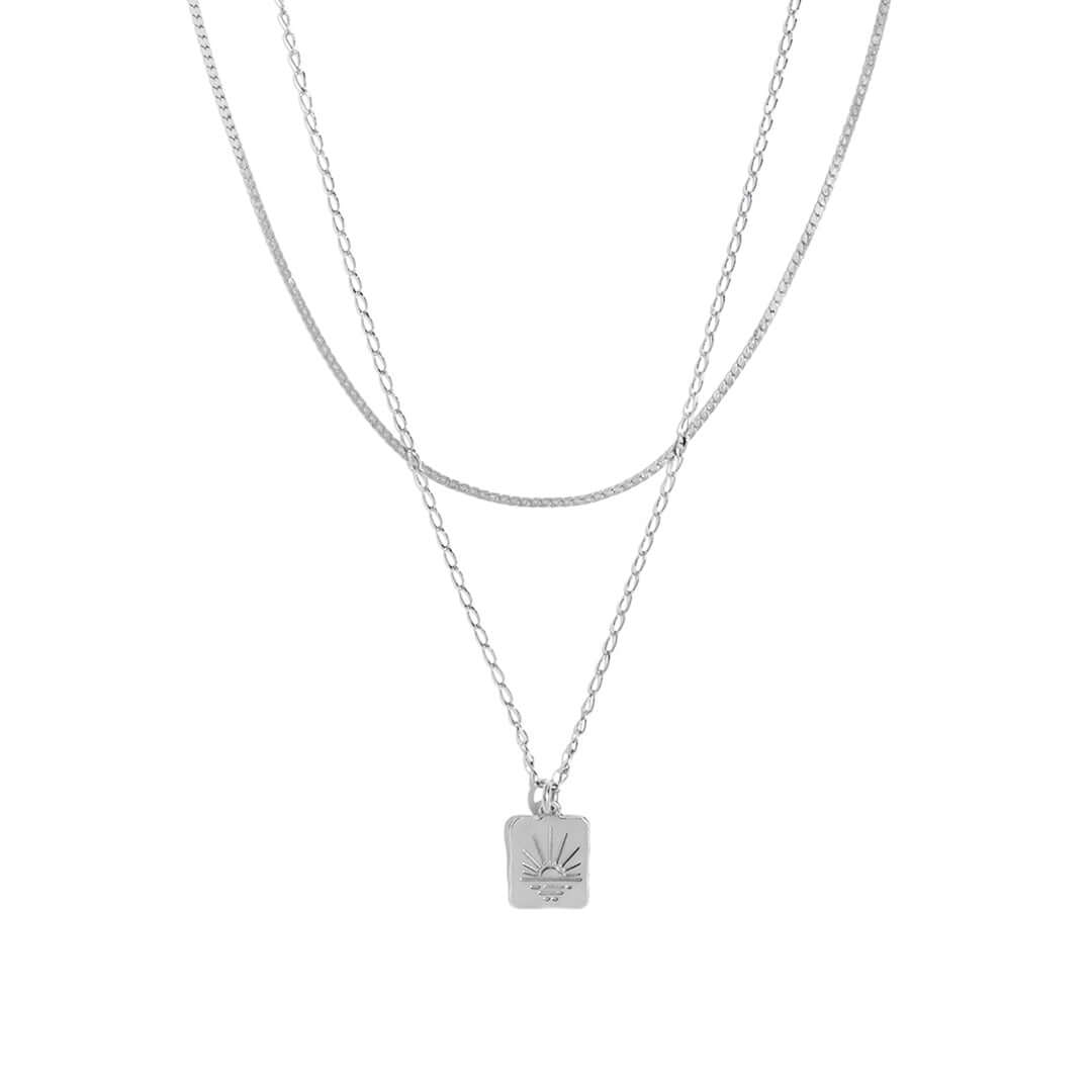Double Sunset Necklace featuring two delicate chains and a sunset-inspired pendant.