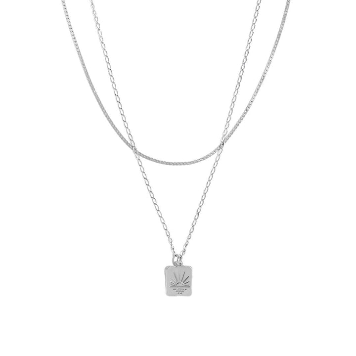 Double Sunset Necklace featuring two delicate chains and a sunset-inspired pendant.