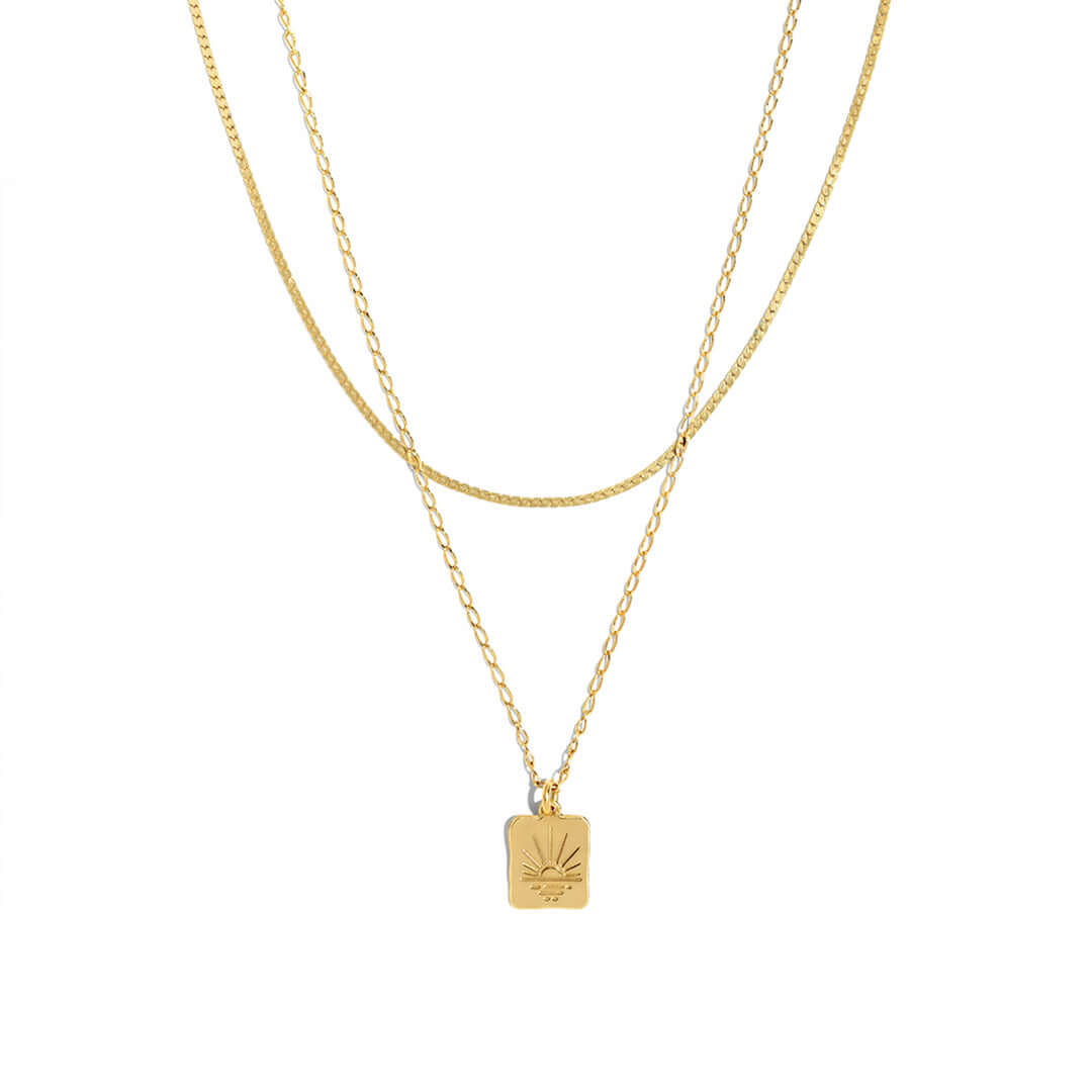 Double Sunset Necklace featuring two delicate gold chains and a sunset-inspired pendant.