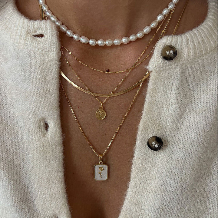 Flory Necklace styled with layered delicate chains and pearl accents for a feminine and stylish look.