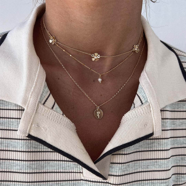 Flower Necklace featuring a dainty pearl and a rose-engraved pendant, perfect for a stylish layered look.