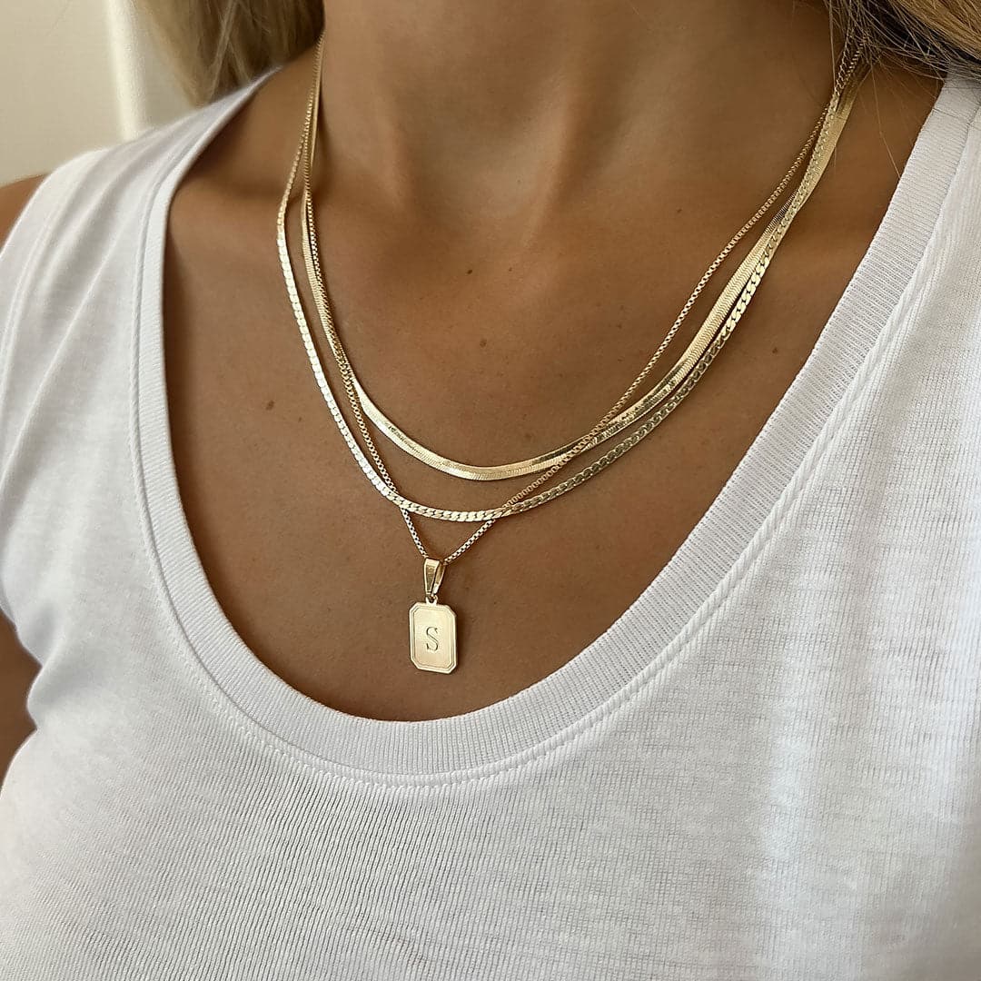 A close-up of a woman wearing the MAAYAN NECKLACE SET 1, featuring layered gold necklaces for a trendy look.