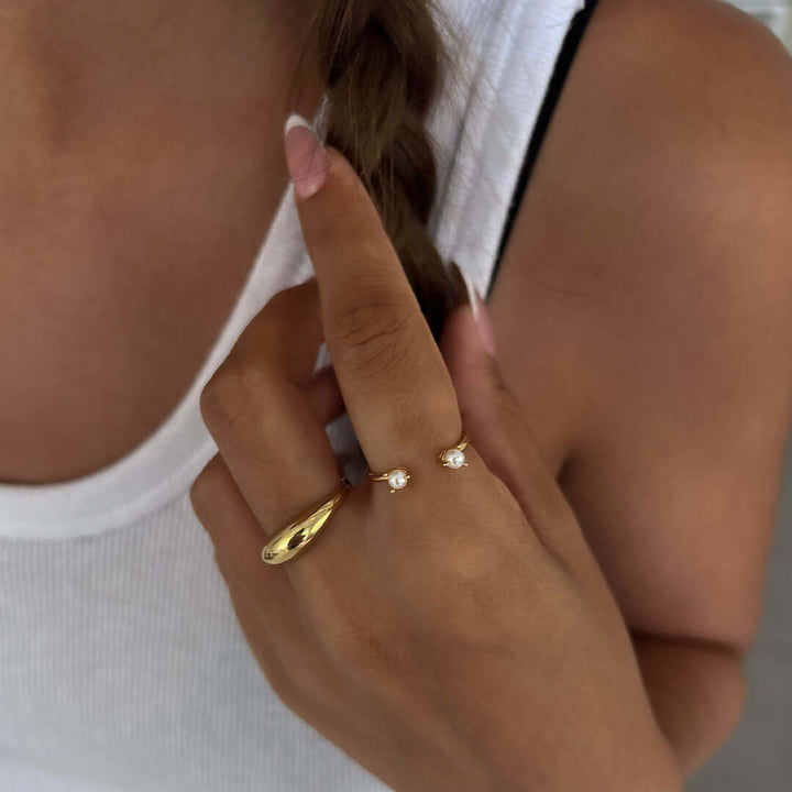 Close-up of a hand wearing a Queen Pearl Ring with freshwater pearls, showcasing its elegant design.