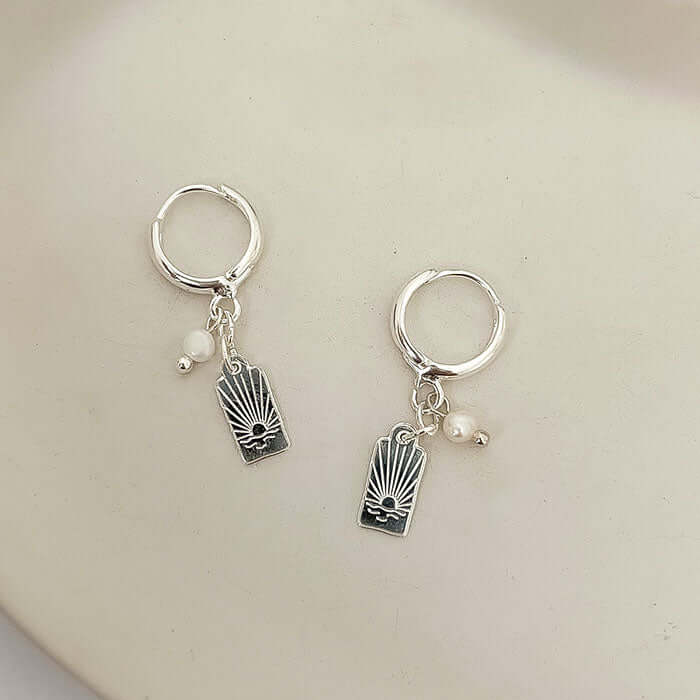 Sunny Earrings featuring dainty drop design with sunset-inspired charm and pearl accents.