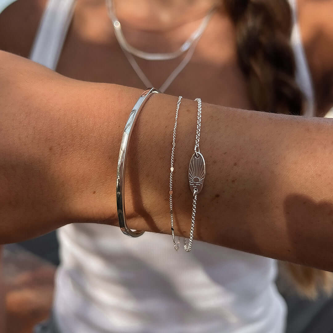 Close-up of a wrist wearing the Sunset Bracelet, showcasing its unique design with a wave pattern and elegant appearance.