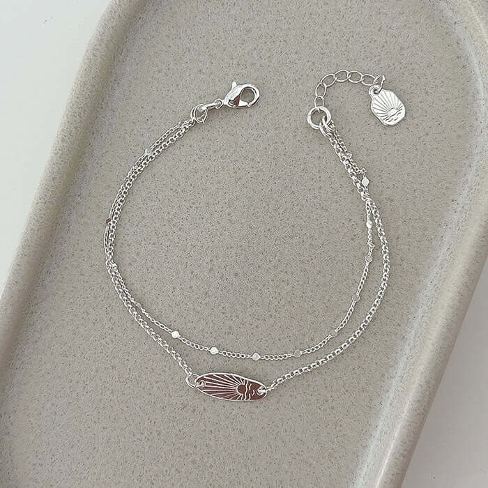 Sunset Bracelet featuring a delicate surfboard shape with a sunset design, perfect for sea lovers and daily wear.