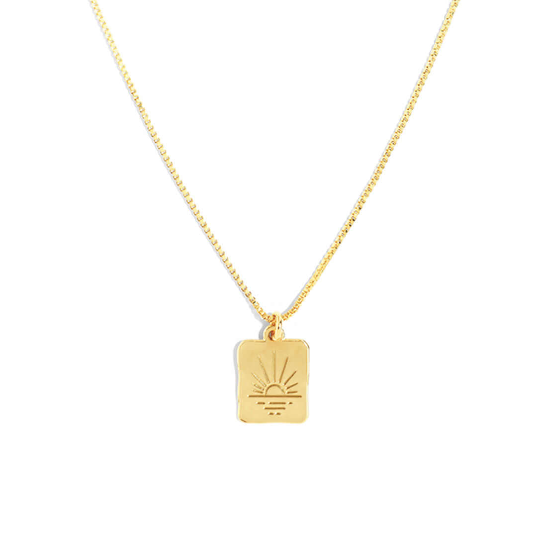 Sunset Necklace with gold charm inspired by the setting sun, symbolizing balance and beauty.